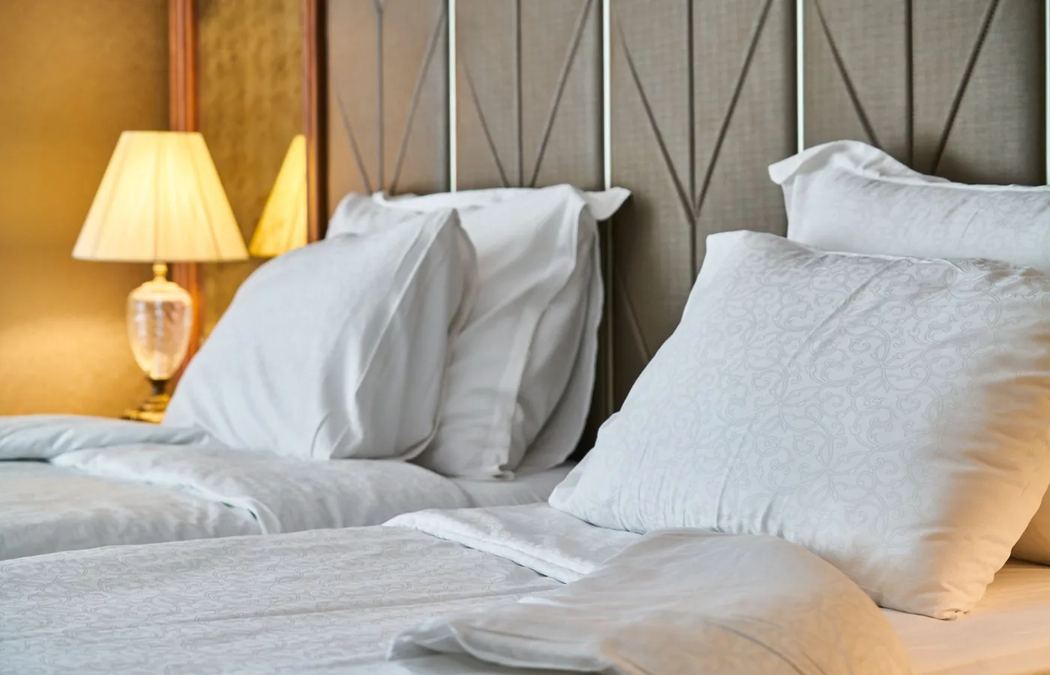Hotel room with white pillows and warm lamplight
